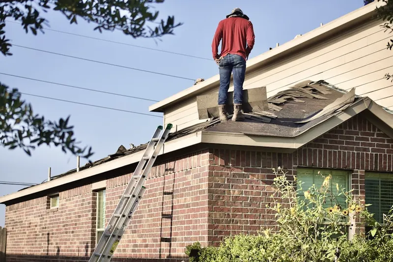 Professional roofer working on a residential roof in Kirby